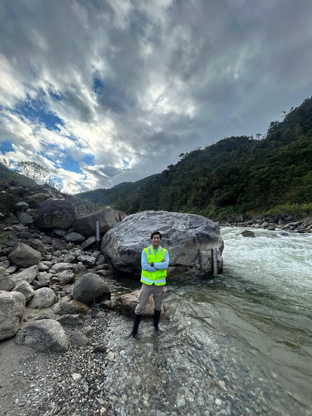 Gabriel Bancayán junto a una mira hidrométrica en un río de montaña